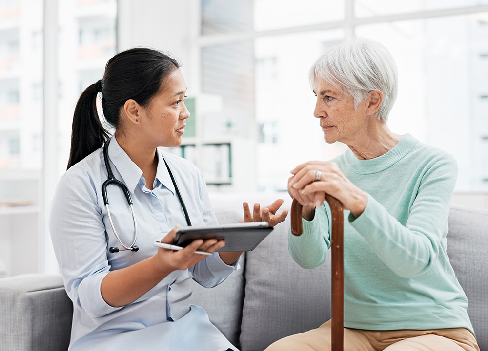 Older female patient in hospital talks to nurse about depression.