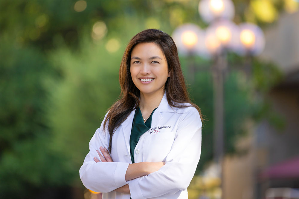 Dr. Jullet Han stands outside and smiles with her arms crossed.
